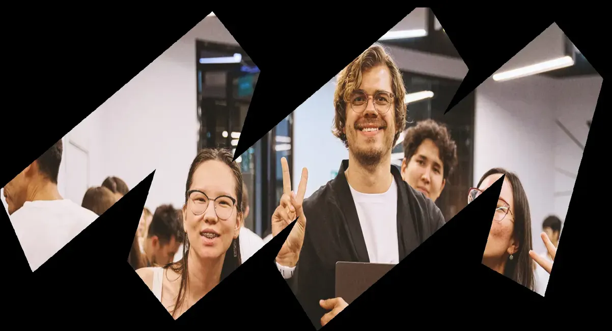 Group photo of smiling coworkers inside geometric cutout shapes.